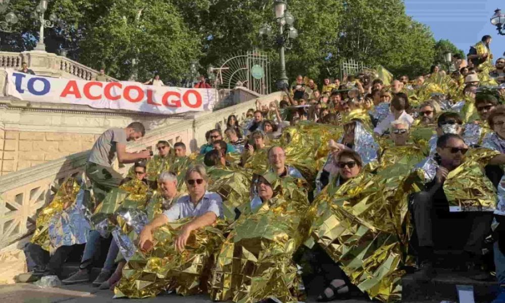 Avvolti nelle coperte termiche sulla scalinata del Pincio per l'inizio della campagna nazionale "Io Accolgo"